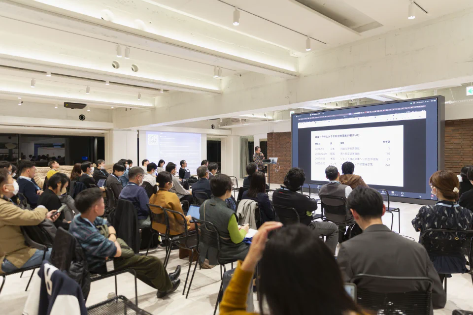 満席の会場で、スクリーンに資料を映しながら登壇者が話している勉強会の様子
